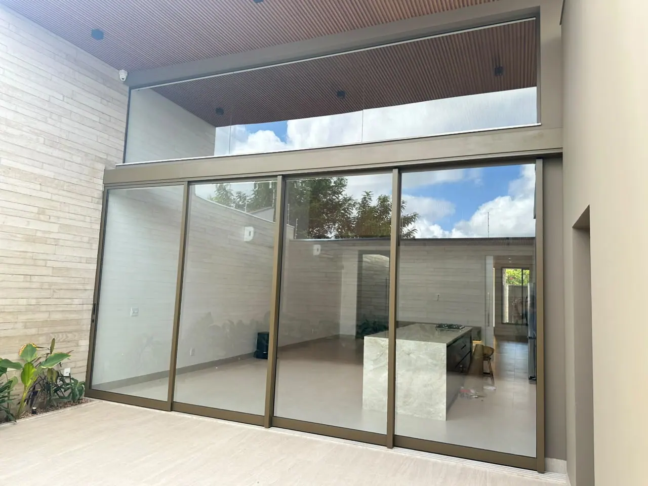 Porta de correr de vidro integrada a projeto residencial com acabamento amadeirado